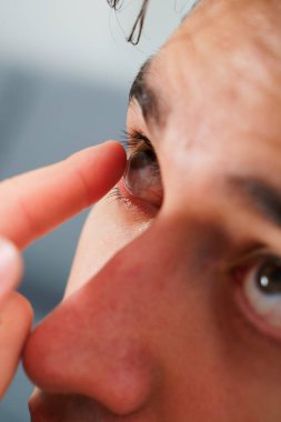 Göz teması lensleriyle göz doktorunun seçtiği görüş düzeltmesi. Adam görüş düzeltmesi için günlük kontak lens takıyor.