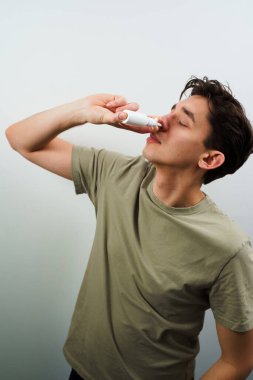 Adam tedavi için burun spreyi kullanıyor. Hasta adam evde akan burundan kurtulmak için burun damlası enjekte ediyor.