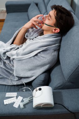 Zatürree tedavisi için nebulizör yoluyla nefes alan hasta. Ev virüsü tedavileri için nebulizatörle nefes almak