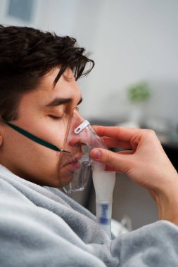 Zatürree tedavisi için nebulizör yoluyla nefes alan hasta. Ev virüsü tedavileri için nebulizatörle nefes almak