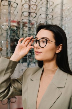 Göz doktoruyla göz sağlığı için gözlük seçiyorum. Sağlık ve vizyon hizmetleri. Kadın optik dükkanında yeni bir gözlük çerçevesi seçiyor.