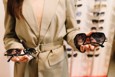 Büyük bir güneş gözlüğü ve optik aksesuar seçimi. Optik mağazada ultraviyole koruma ile farklı çerçevelerden güneş gözlüğü seçmek