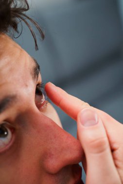 Optik kontakt lenslerle göz sağlığını düzeltiyorum. Adam miyop tedavisi için gözüne kontak lens takar