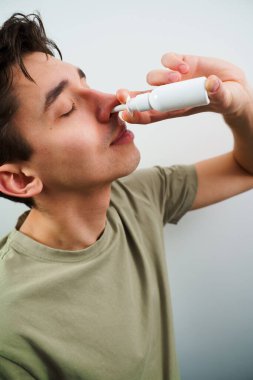 Adam tedavi için burun spreyi kullanıyor. Hasta adam evde akan burundan kurtulmak için burun damlası enjekte ediyor.