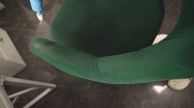 Temizlikçi 4k 'lık kanepedeki lekeleri çıkarmak için deterjan sıkıyor. Döşemeleri deterjan püskürterek temizliyorum..