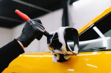 Arabanın aynasına sabunlu bir solüsyon sürme prosedürünü fırça kullanarak detaylandırıyorum. Oto yıkamada çok titiz bir araba.