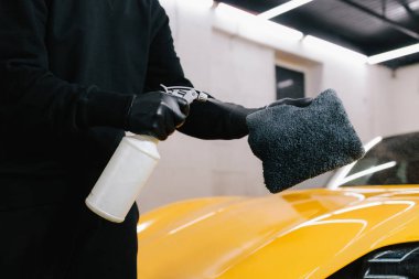 Araba koruması için sprey ağda ürününü kullanarak süreci detaylandırıyorum. Araba temizleyicisi servisteki mikrofiber kumaşa ağda yapmak için sıvı püskürtüyor.