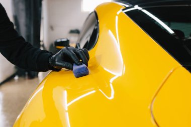 Araba servisinde seramik cilalama ayrıntıları. Seramik kaplamanın spor araba yüzeyine uygulanma süreci hizmetin ayrıntılı oturumunda korunmak için