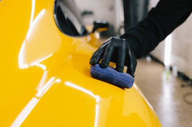 Seramik kaplama işlemi, servisteki detaylı oturum sırasında korunmak için spor araba yüzeyine uygulanır. Araba servisinde seramik cilalama ayrıntıları