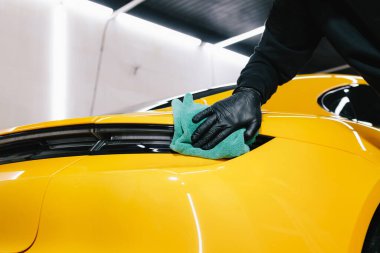 Detaylı işlemden sonra mikrofiber bezle el yıkama ve araba cilalama. Garajda mikrofiber havlu kullanarak el temizleme ve spor araba yıkama.