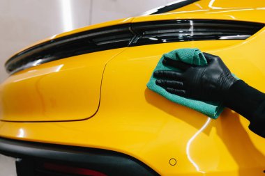 Detaylı işlemden sonra mikrofiber bezle el yıkama ve araba cilalama. Garajda mikrofiber havlu kullanarak el temizleme ve spor araba yıkama.