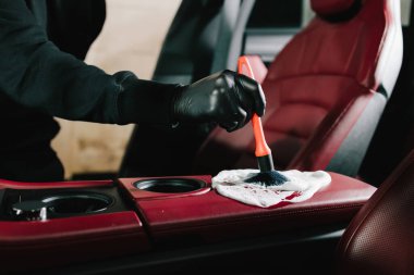 Çamaşır makinesi serviste iç temizlik için arabanın kırmızı derisine köpük sürer. Araba yıkatma işlemi araba yıkamada sabun köpüğüyle temizleniyor.