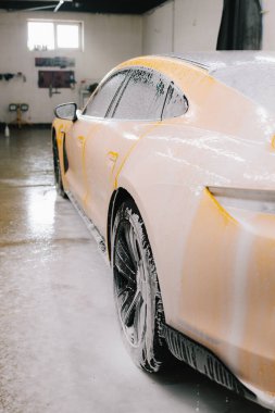 Titiz araba temizliği sırasında sabunla yıkama işlemi. Oto servisinde sabun köpüğüyle yıkama sırasında spor araba.