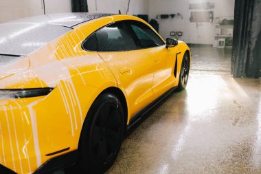 Titiz araba temizliği sırasında sabunla yıkama işlemi. Oto servisinde sabun köpüğüyle yıkama sırasında spor araba.