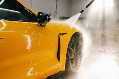 Araba yıkamada su tabancasından araba yıkama işleminin ayrıntıları su tabancasından arabaya kadar olan basınç altında su uygulanması.