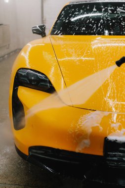 Araba yıkamada su tabancasından araba yıkama işleminin ayrıntıları su tabancasından arabaya kadar olan basınç altında su uygulanması.