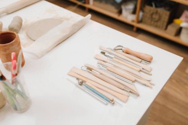 Küf seramikleri için çanak çömlek vitesleri. Çömlekçilik atölyesindeki masanın üzerinde heykel aletleri var.