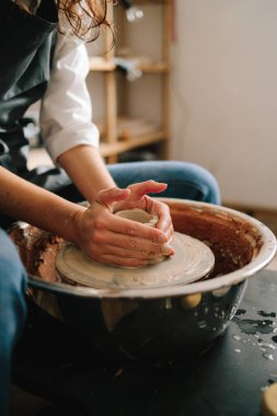 Potter çömlek atölyesinde seramik bir kase yapıyor. Eşsiz bir seramik şekil oluşturma süreci
