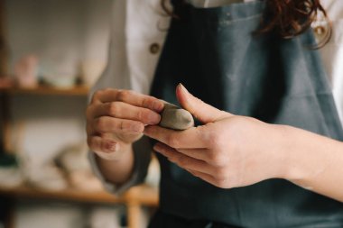 Potter ıslak bir kil parçasını ellerinde tutuyor ve onu şekillendiriyor. Seramik ürünler oluşturma süreci