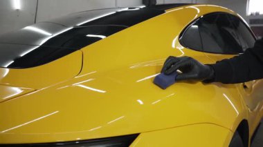 Seramik kaplama işlemi, servisteki detaylı oturum sırasında korunmak için spor araba yüzeyine uygulanır. 4k video servisinde seramik cilalama detaylandırılıyor