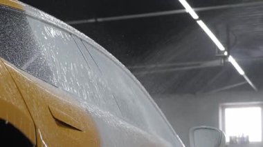 Yüksek basınçlı su tabancası, araçların yüzeyine sabun püskürtüyor. Detaylı temizlik videosu için. Araba yıkamada toz ve çamurdan araba temizliği.