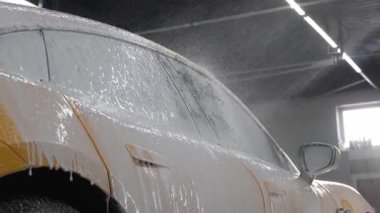 Yüksek basınçlı su tabancası, araçların yüzeyine sabun püskürtüyor. Detaylı temizlik videosu için. Araba yıkamada toz ve çamurdan araba temizliği.