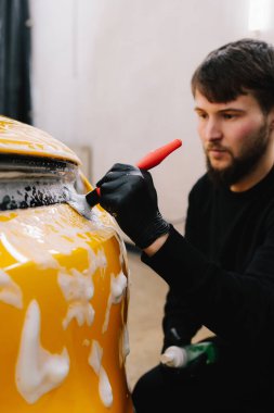 Farları köpük ve yumuşak fırçayla yıkama prosedürü. Araba yıkamada temizlik fırça ve köpükle yapılır.