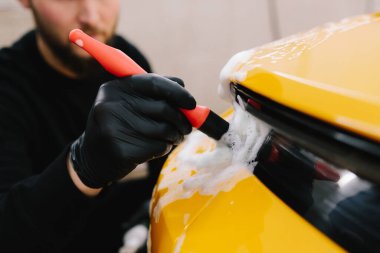 Farları köpük ve yumuşak fırçayla yıkama prosedürü. Araba yıkamada temizlik fırça ve köpükle yapılır.