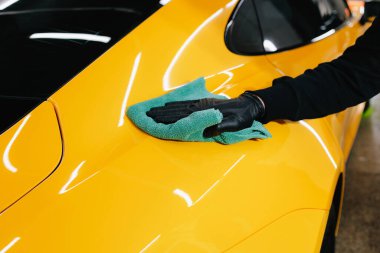 Detaylı işlemden sonra mikrofiber bezle el yıkama ve araba cilalama. Garajda mikrofiber havlu kullanarak el temizleme ve spor araba yıkama.