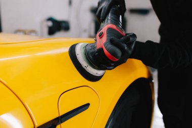 Yörünge cilası cilalayan araba tamircisinin elleri. Araç temizleme ve vale prosedürü