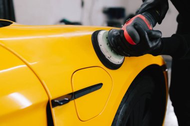 Yörünge cilası cilalayan araba tamircisinin elleri. Araç temizleme ve vale prosedürü