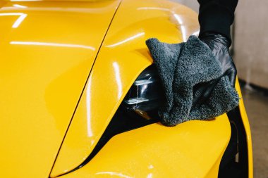 Spor araba temizleme işlemi. Farı mikrofiber bezle parlatmak. İşçi araba farı cilası için mum sıvısı kullanır