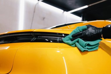 Detaylı işlemden sonra mikrofiber bezle el yıkama ve araba cilalama. Garajda mikrofiber havlu kullanarak el temizleme ve spor araba yıkama.