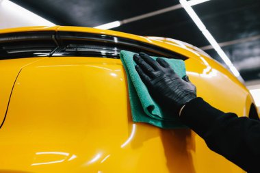 Detaylı işlemden sonra mikrofiber bezle el yıkama ve araba cilalama. Garajda mikrofiber havlu kullanarak el temizleme ve spor araba yıkama.