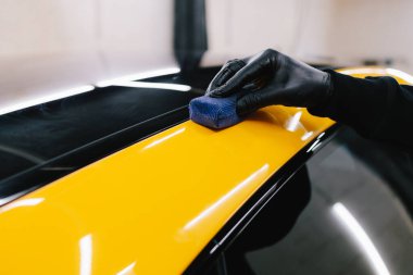 Seramik kaplama işlemi, servisteki detaylı oturum sırasında korunmak için spor araba yüzeyine uygulanır. Araba servisinde seramik cilalama ayrıntıları