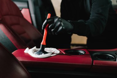 Çamaşır makinesi serviste iç temizlik için arabanın kırmızı derisine köpük sürer. Araba yıkatma işlemi araba yıkamada sabun köpüğüyle temizleniyor.