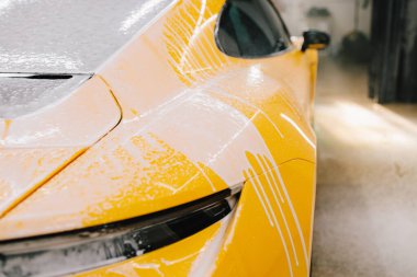 Titiz araba temizliği sırasında sabunla yıkama işlemi. Oto servisinde sabun köpüğüyle yıkama sırasında spor araba.