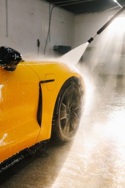 Araba yıkamada su tabancasından araba yıkama işleminin ayrıntıları su tabancasından arabaya kadar olan basınç altında su uygulanması.