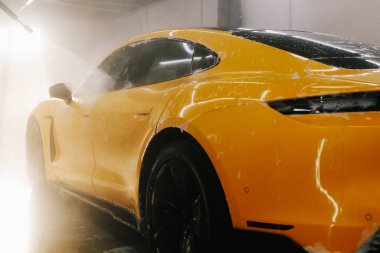 Araba yıkamada su tabancasından araba yıkama işleminin ayrıntıları su tabancasından arabaya kadar olan basınç altında su uygulanması.