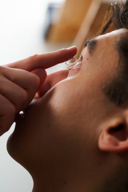 Göz teması lensleriyle göz doktorunun seçtiği görüş düzeltmesi. Adam görüş düzeltmesi için günlük kontak lens takıyor.