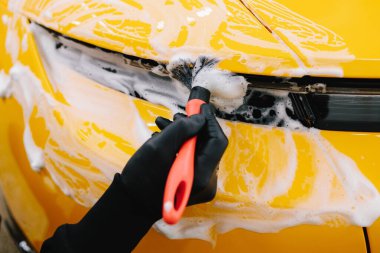 Farları köpük ve yumuşak fırçayla yıkama prosedürü. Araba yıkamada temizlik fırça ve köpükle yapılır.