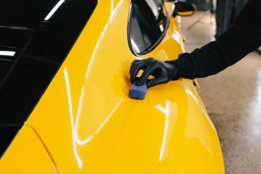 Seramik kaplama işlemi, servisteki detaylı oturum sırasında korunmak için spor araba yüzeyine uygulanır. Araba servisinde seramik cilalama ayrıntıları