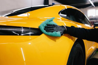 Detaylı işlemden sonra mikrofiber bezle el yıkama ve araba cilalama. Garajda mikrofiber havlu kullanarak el temizleme ve spor araba yıkama.