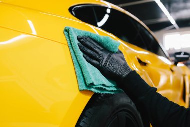 Detaylı işlemden sonra mikrofiber bezle el yıkama ve araba cilalama. Garajda mikrofiber havlu kullanarak el temizleme ve spor araba yıkama.