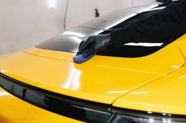 Arabayı çiziklerden korumak için nano seramik koruyucu palto kullanıyorum. Otomobil servisinin detaylandırılmasında sünger yakın çekim kullanılarak seramik katman uygulanması işlemi