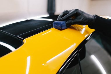 Seramik kaplama işlemi, servisteki detaylı oturum sırasında korunmak için spor araba yüzeyine uygulanır. Araba servisinde seramik cilalama ayrıntıları