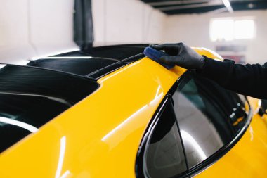 Seramik kaplama işlemi, servisteki detaylı oturum sırasında korunmak için spor araba yüzeyine uygulanır. Araba servisinde seramik cilalama ayrıntıları