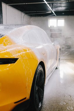 Araba yıkama yerindeki kiri ve tozu temizlerken yüksek basınçlı su tabancası sabunlu çözeltiyi aracın yüzeyine sıkarak temizler.