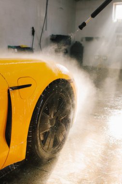 Araba yıkamak için yüksek basınçlı su tabancası kullanmak. Araba yıkamada su tabancasından araba yıkama işlemi.