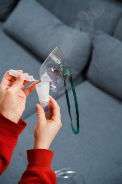 Solunum tedavisi için tıbbi çözelti damlatıyor. Evde kullanılmadan önce kompresör nebulizer hazırlama süreci